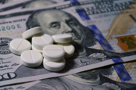 Tablets on 100 dollar banknotes. Pills on 100 dollar banknotes