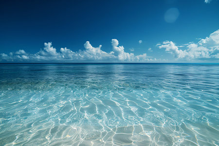 Expansive view of calm turquoise ocean water under a clear blue sky with light clouds.の素材