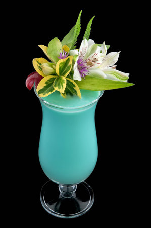 Blooming alcohol blue drink with flowers and cherry, isolated black backgroundの写真素材