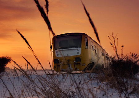 Modern train at sunset in winter landscapeの写真素材