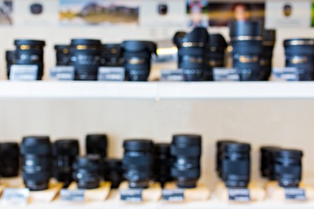 Blurry cameras and lenses in camera store shelf. Great image for your backgroundの写真素材