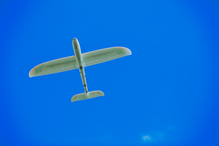 Airplane model flying in a summer skyの写真素材