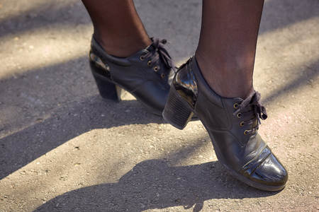 Womens legs in black stockings black shoes on the asphaltの写真素材