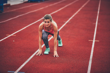 Muscular and beautiful girl doing exercises. Athletics girl, stadium