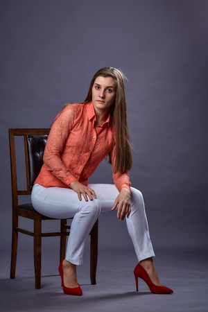 Beautiful sexy girl in casual clothes posing in photo studio on a homogeneous background. Womans portrait, emotionsの写真素材