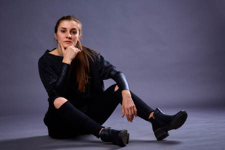 Beautiful sexy girl in casual clothes posing in photo studio on a homogeneous background. Womans...
