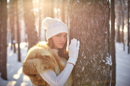 beautiful girl in fur vest in winter forest
