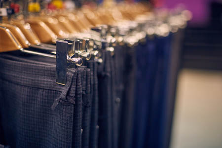 Showcase with mens trousers on hangers in a mens storeの写真素材