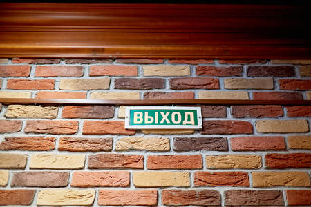 plaque with the inscription exit in Russian on a brick wall above the doorの写真素材