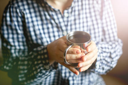 Womens hands hold a cup of tea, toningの写真素材