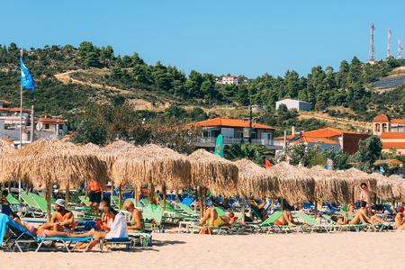 SARTI, GREECE - SEPTEMBER 23, 2014: tourists sunbathe and swim on the beach of the Mediterranean Seaのeditorial素材
