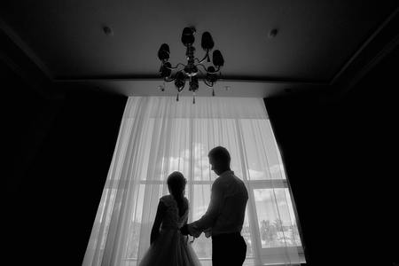 the bride and groom in the morning at the hotel on a wedding day. Dressing a newly-married coupleの写真素材