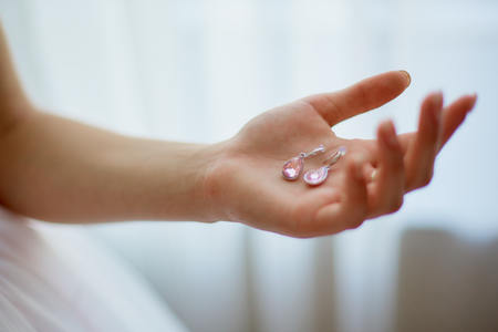 The bride is putting on earrings on her wedding dayの写真素材