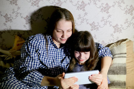 Mother and children with a tablet computer at home watching cartoons and playingの写真素材