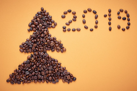 Christmas tree of coffee beans on orange background