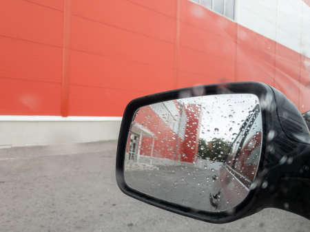cloudy and rainy autumn day, view of the city from the car window, side mirror viewの写真素材