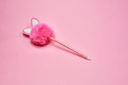 Pink fluffy rabbit in the form of a pompom and a pen on a pink background. Creative rabbit pompom with cute ears. copy space . Easter Bunny rabbitの写真素材