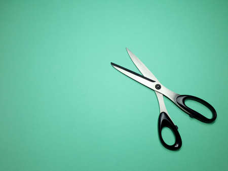 tailor scissors for cutting fabric on a green backgroundの写真素材