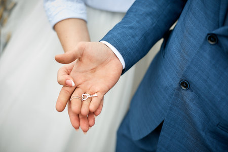 the hands of the bride and groom hold a small key.の写真素材