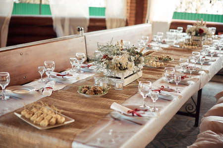 Decorated elegant wooden wedding table for banquet outdoor in garden gazeboの写真素材