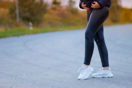 womens legs in latex leggings in the park.