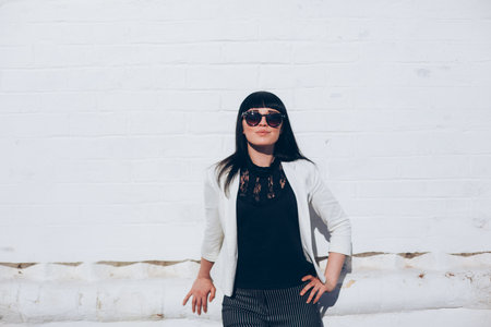 portrait of a stylish brunette in sunglasses on a sunny dayの写真素材