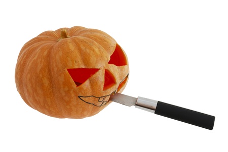 Halloween jack o lantern preparation - carving pumpkin with knife isolated on white backgroundの写真素材