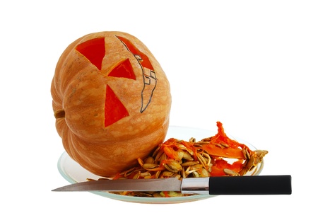 Halloween jack o lantern preparation - carving pumpkin with knife isolated on white backgroundの写真素材