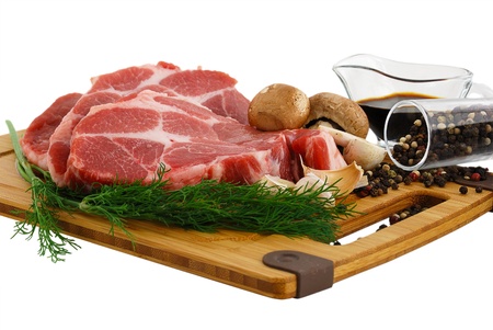 Raw steak with portobello mushrooms, pepper and soy sauce on cutting board isolated on white background の写真素材