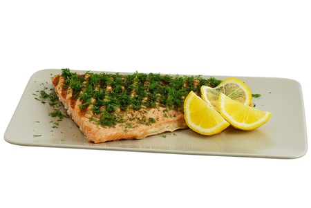 Grilled salmon fish fillet with dill and lemon on grey ceramic dish isolated on white backgroundの写真素材