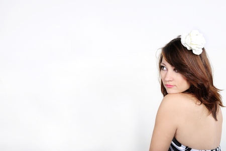 The young beautiful girl on a white background with a white flowerの写真素材
