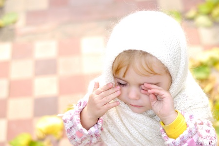 Portrait of the small beautiful girl in a white scarfの写真素材