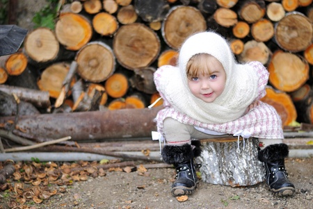 The small terrible girl in a white scarf sits on hempの写真素材