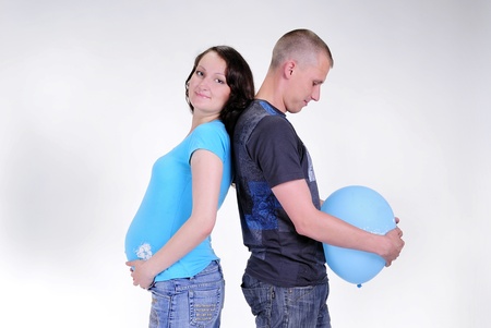 The young pregnant girl with the husband and blue a balloonの写真素材