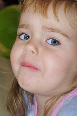 Portrait of the small beautiful girl with a sad face
