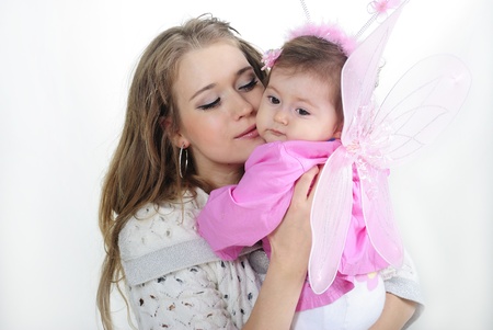 The small beautiful girl at mum on hands on a white background with wingsの写真素材