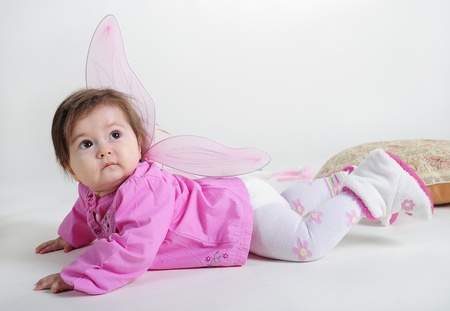 The small beautiful girl in pink clothes on a white backgroundの写真素材
