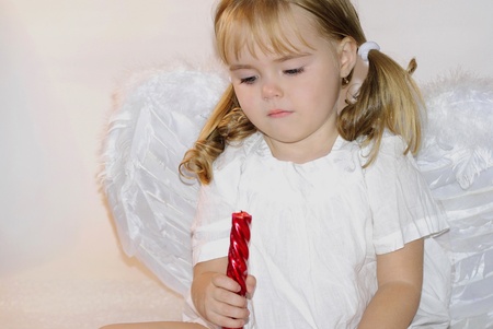 small beautiful girl angel with êðûëûøêàìè and candleの写真素材