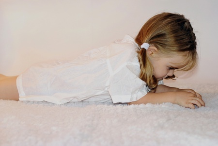 small beautiful offended girl rests upon bedsの写真素材