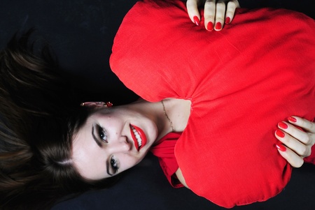 making look younger beautiful bright girl with red heart in handの写真素材