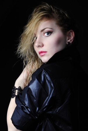 Beautiful girl blonde in black shirt on black background with wet hair and bracelet
の写真素材