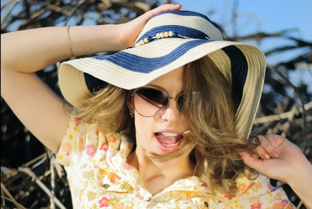 beautiful girl in shorts and hat on grapevine