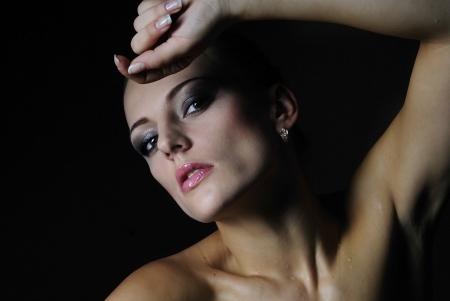 beautiful girl model with wet body on dark backgroundの写真素材