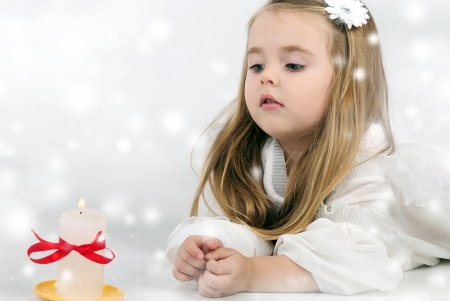 A beautiful little girl angel with a candleの写真素材