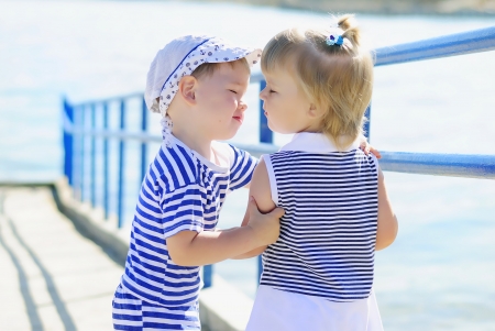 the little kids kissing by the seaの写真素材