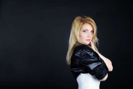Beautiful girl blonde in white and black shirt on black backgroundの写真素材