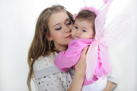 The small beautiful girl at mum on hands on a white background with wingsの写真素材
