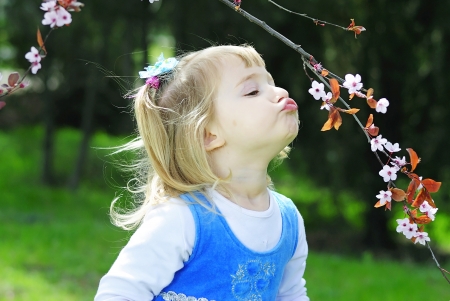little girl on green grass in the spring in a Blue Dressの写真素材
