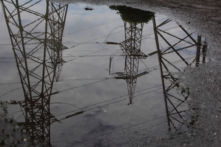Reflection power lines in rain puddleの写真素材