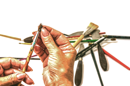 Golden hands of the artist choose a brush for drawing, close-up.の写真素材